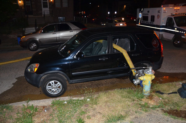 A hose runs from a fire hydrant through two windows of a Honda SUV in Pennsauken after crews responded to a house fire on May 27, 2015. (Photo courtesy of Ted Aurig)